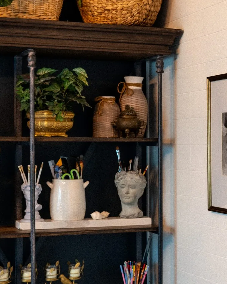 The studio: brushes, plaster casts and jars beside the wall of work